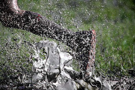 Runner splashing through mud