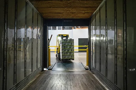 Forklift driving onto a truck