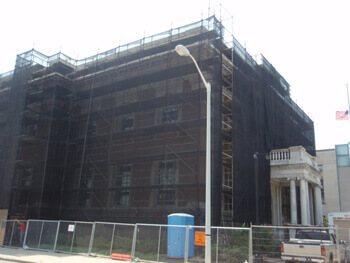 Corner of building covered with debris netting
