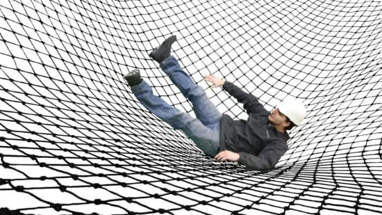 A falling man caught on the ground inside of a net