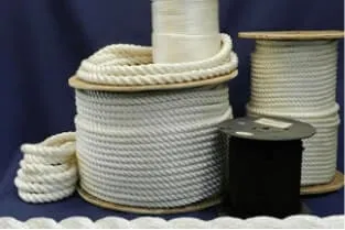 Multiple spools of white nylon rope in various sizes and thicknesses are displayed against a blue backdrop. Some of the nylon ropes are coiled on larger spools while others are on smaller reels or bundled loosely.